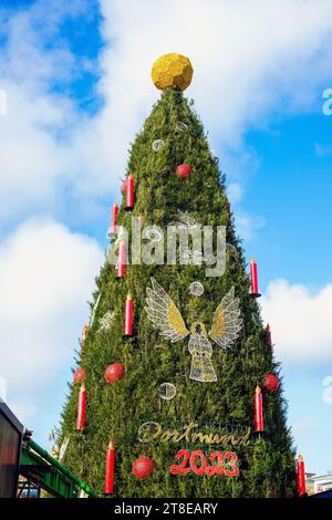 Dortmund/Germania, 20 novembre 2023: Una palla d'oro incorona l'albero di Natale più grande del mondo al mercato di Natale di Dortmund. L'albero è alto 45 metri, è composto da 1.700 abeti rossi del Sauerland ed è appeso con 48.000 luci a LED. La palla in alto assomiglia a un calcio ed è quindi criticata come insapore e inappropriato per Natale -- Eine goldene Kugel krönt den weltweit größten Weihnachtsbaum auf dem Dortmunder Weihnachtsmarkt. Der Baum ist 45 Meter hoch, besteht aus 1700 Rotfichten aus dem Sauerland und ist mit 48,000 LED-Lichtern behängt. Die Kugel auf der SP Foto Stock