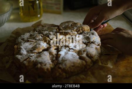 Le mani delle donne vogliono prendere un pezzo di torta di mele charlotte pronta Foto Stock
