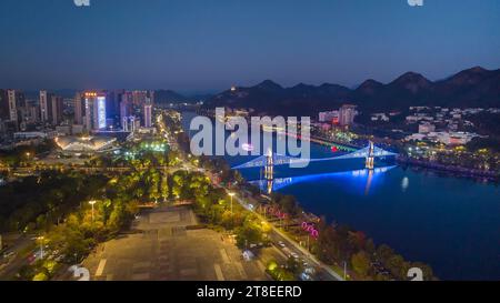 Pechino, Cina. 20 novembre 2023. Questa foto aerea scattata il 20 novembre 2023 mostra un ponte illuminato per celebrare la giornata Mondiale dei bambini sul fiume Xin'an nella città di Huangshan, nella provincia di Anhui della Cina orientale. Crediti: Fan Chengzhu/Xinhua/Alamy Live News Credit: Xinhua/Alamy Live News Foto Stock