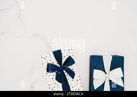 Due confezioni regalo avvolte in carta e legate con nastro su sfondo bianco. Copia spazio. Spianatura piatta. Vista dall'alto. Blu e bianco Natale minimale, Capodanno Foto Stock