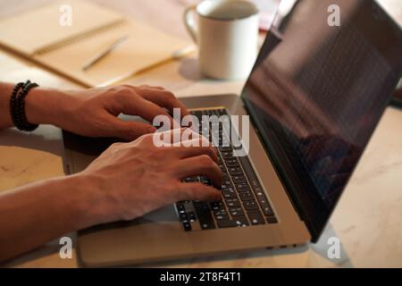 Mani di un uomo d'affari che lavora con dati di trading su laptop Foto Stock