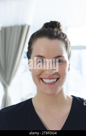 Ritratto di felice medico caucasico femminile in soleggiata stanza d'ospedale Foto Stock