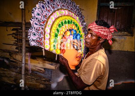 Tehatta, India. 20 novembre 2023. Un artista a Tehatta, Bengala Occidentale, India, sta attualmente creando grandi maschere colorate modellate sulle maschere di danza Purulia Chhau, ispirate da dee, animali e rakshasa della mitologia indù. Le maschere sono fatte di argilla e vengono dipinte e adornate con ornamenti prima di essere installate in un pandalo Jagaddhatri Puja. I lavoratori stanno attualmente trasportando le maschere finite in auto il 20 novembre 2023. (Foto di Soumyabrata Roy/NurPhoto) credito: NurPhoto SRL/Alamy Live News Foto Stock