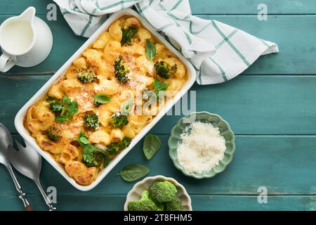 Casseruola di pasta Broccoli. Mac al forno e formaggio con broccoli, salsa cremosa e parmigiano su un vecchio sfondo rustico in legno. Alimenti sani o per bambini. Americano Foto Stock