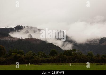 Paesaggio di una campagna in una giornata fredda con nebbia che si innalza dalle montagne Foto Stock