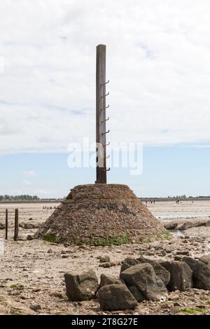 Pilastro di legno dotato di una scala in caso di improvviso aumento della marea lungo il Passage du Gois, una strada sommersa ad ogni marea. Foto Stock