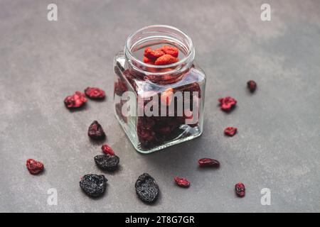 Vista dall'alto mirtilli rossi all'interno di un vaso trasparente, con sfondo nero Foto Stock