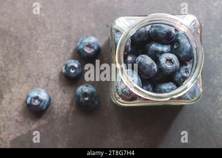 Mirtilli rossi con vista dall'alto all'interno di un vaso trasparente, con sfondo nero Foto Stock