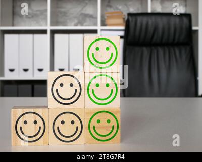 Sondaggio sulla soddisfazione dei dipendenti. Cubi con facce felici in ufficio. Foto Stock