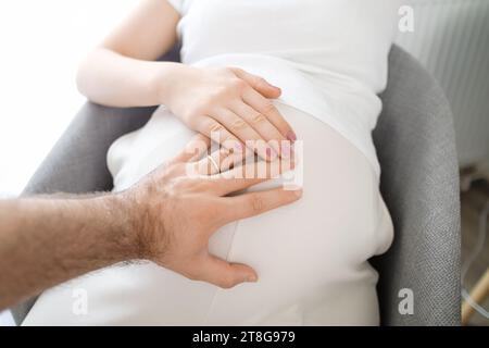 Uomini e donne mani sullo stomaco incinta. Aspettavo un bambino. Foto Stock