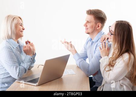 Donna d'affari anziana attraente impegnata in conversazione con i giovani, donna anziana che funge da istruttrice a un seminario di formazione, donna Foto Stock