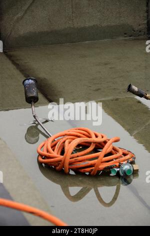 Il tubo flessibile e il bruciatore di una bombola di gas sono nell'acqua Foto Stock