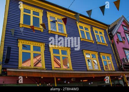 Stavanger, ventanas con sus reflejos en una de las casas de colores brillantes, azul y amarillo, en la calle Øvre Holmegate o Fargegaten, Noruega Foto Stock