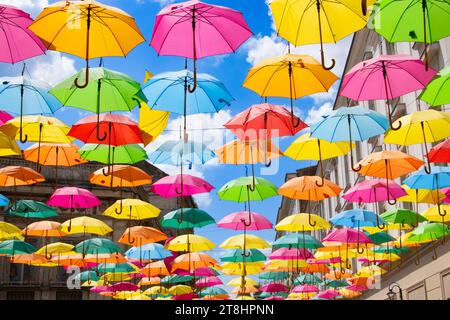 Ombrelli multicolori contro un cielo blu Foto Stock