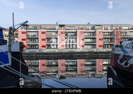 Nancy, Francia - concentrazione su un moderno edificio residenziale rosa costruito nel 2005 di fronte al canale navigabile e alle sue chiatte. Foto Stock