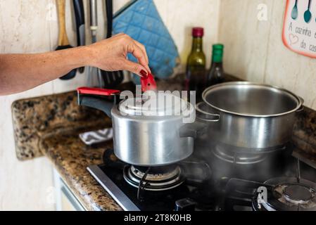Rimuovere manualmente la pressione dell'aria da una coppa. Cura in cucina. Foto Stock