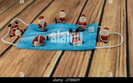 Santa Klauses con maschera chirurgica e provetta, Natale con Corona Foto Stock