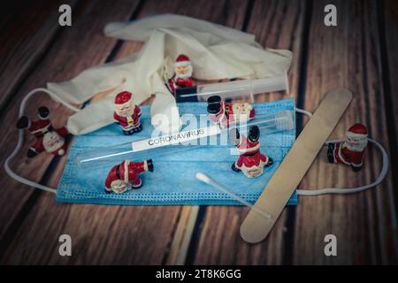 Santa Klauses con maschera chirurgica e provetta, immunizzazione, Natale con Corona Foto Stock