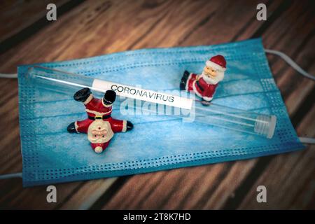 Santa Klauses con maschera chirurgica e provetta, Natale con Corona Foto Stock