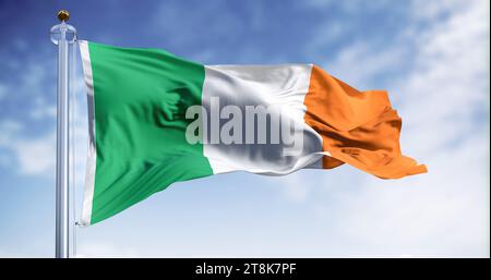 Bandiera nazionale irlandese che sventola nel vento in una giornata limpida. Tricolore verticale di verde, bianco e arancione. Membro dello stato dell'Unione europea. illustrazione 3d. Foto Stock