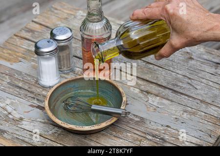 mescolare in un recipiente il condimento autopreparato per insalata di erbe, aceto, olio, salz e pepe Foto Stock