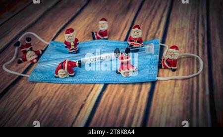 Santa Klauses con maschera chirurgica e provetta, Natale con Corona Foto Stock