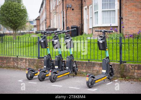 YORK, Regno Unito - 17 aprile 2023. Fila di scooter elettrici a noleggio (e-scooter) parcheggiati in una strada cittadina a York, Regno Unito Foto Stock