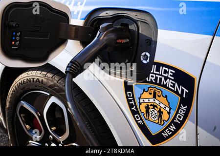 New York, New York - 20 novembre 2023: Servizio di polizia City of New York ricarica di auto di pattuglia EV con presa per veicolo elettrico ChargePoint sulla strada all'esterno Foto Stock