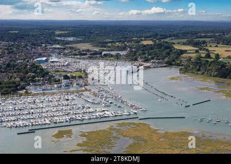 Fotografia aerea del fiume Lymington che incontra l'acqua soleggiata nella New Forest con la città di Lymington sullo sfondo Foto Stock