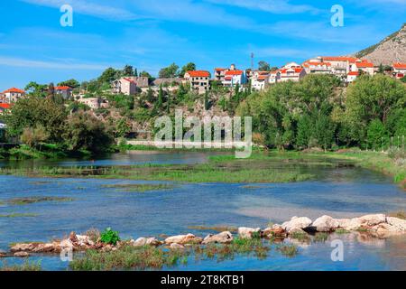 Paesaggi pittoreschi della Bosnia ed Erzegovina, città di Trebinje lungo le rive del fiume, una serie di case salgono su una collina, creando un paesaggio affascinante ag Foto Stock