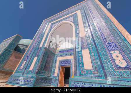 24 GIUGNO 2023, SAMARCANDA, UZBEKISTAN: Ornamento decorativo simmetrico di ingresso alla tomba e porta aperta a Shah-i-Zinda, un complesso commemorativo, necro Foto Stock