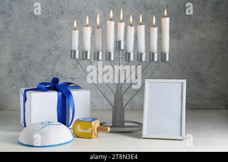 Menorah, cornice vuota, regalo e simboli Hanukkah su sfondo grunge Foto Stock