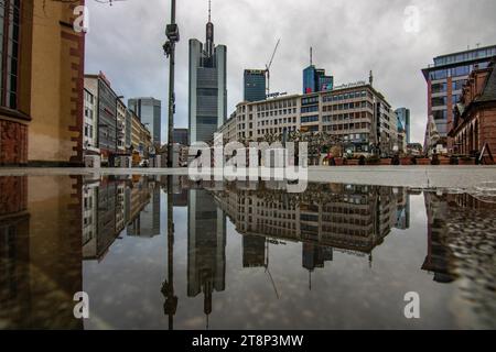 Riflesso in una pozzanghera tra grattacieli. Paesaggio urbano con edifici e strade moderni. Compagnie assicurative e banche come paesaggio urbano Foto Stock