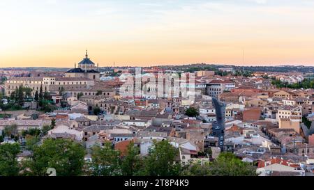 Toledo (Spagna) paesaggio al tramonto con architettura residenziale spagnola, la torre del Colegio San Juan Bautista in lontananza. Foto Stock