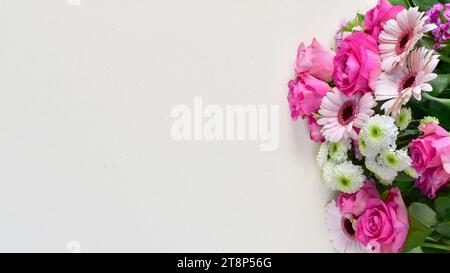 Bellissimo bouquet di fiori rosa su biglietto d'auguri di carta riciclata bianca, spazio per copiare il testo Foto Stock