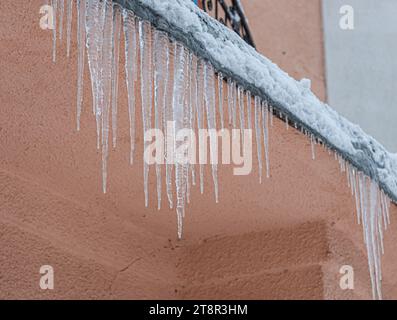 Ghiaccioli sul tetto. Lo scarico è pieno di neve e ghiaccio. Ghiaccio cadere concetto di pericolo. Foto Stock