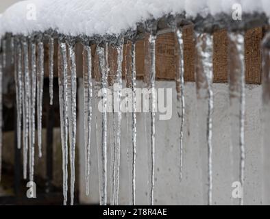 Ghiaccioli sul tetto. Lo scarico è pieno di neve e ghiaccio. Ghiaccio cadere concetto di pericolo. Foto Stock