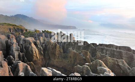 Il Pancake Rocks Punakaiki. Nuova Zelanda, le famose Pancake Rocks e Blowholes sono ad appena 20 minuti a piedi dal percorso dove parcheggiate il vostro veicolo sull'autostrada principale a Punakaiki. Assomigliando a pancake giganti, le curiose formazioni calcaree sono particolarmente spettacolari con l'alta marea in un mare occidentale Foto Stock