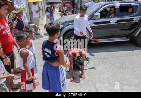 Bambini flog un penitente sanguinante, sfilata dei flagellanti, settimana Santa, Venerdì Santo, rituali Filippine, Maleldo, vera crocifissione, sanguinosa pasqua flogging Foto Stock