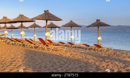 Ombrelloni in paglia su una spiaggia sull'isola di Lesbo in Grecia. Scenario idilliaco della spiaggia dell'isola greca. Europa Foto Stock