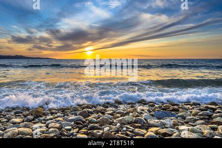 Onde del mare Mediterraneo che si infrangono sulla spiaggia di ciottoli vicino a Farinole Cap Corse, Corsica, Francia Foto Stock