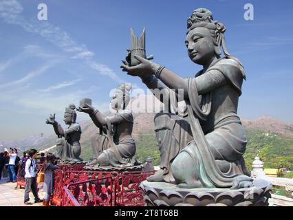 Statue po Lin Monastero. HK, tre donne di statura che offrono doni al grande Buddha di Hong Kong, come viene chiamato anche il Buddha Tian Tan, è una delle principali attrazioni dell'isola di Lantau. Insieme al villaggio di Ngong Ping e al monastero di po Lin, il Tian Tan Buddha è una destinazione popolare per una gita di un giorno a Hong Kong Foto Stock