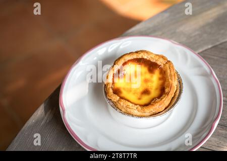 Crostata all'uovo portoghese su un piatto bianco. Deliziosa pasta. Foto Stock