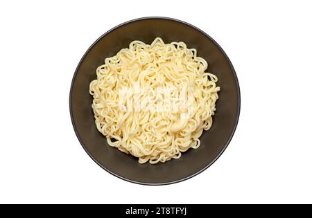 Tagliatelle istantanee, cotte, in un recipiente scuro profondo, vista dall'alto, isolate su sfondo bianco con percorso di ritaglio. Foto Stock