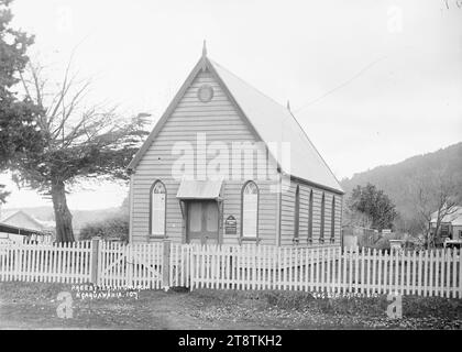 Chiesa presbiteriana, Ngaruawahia, nuova Zelanda -, Vista della piccola Chiesa presbiteriana in legno a Ngaruawahia, nuova Zelanda, probabilmente conosciuta come Knox Presbyterian Church. La chiesa ha una recinzione bianca davanti e un albero di macrocarpa che cresce sulla sinistra. Ci sono colline in lontananza. (Probabilmente Green & Colebrook, commercianti, con una filiale a Ngaruawahia, nuova Zelanda) nei primi anni '1900; una copia in William A Price Collection Foto Stock