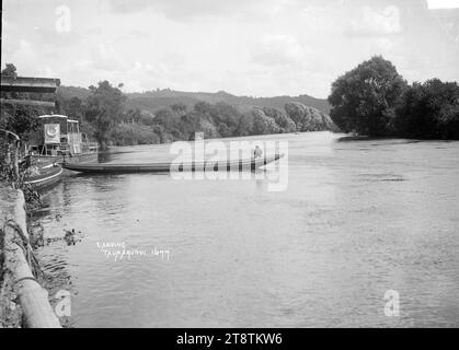 Uno sbarco sul fiume Whanganui a Taumarunui, veduta di uno sbarco sul fiume Whanganui a Taumarunui, con un battello a vapore lungo lo sbarco, e una canoa motorizzata che si estende nel fiume. tra 1900 e 1930 Foto Stock