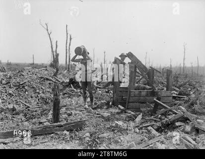 Un soldato neozelandese beve da un pozzo in rovina Puisieux, La prima guerra mondiale, Un soldato neozelandese che beve da un secchio di acqua nelle rovine del villaggio francese di Puisieux. Guarda un altro soldato. A parte il pozzo che rimane funzionante, tutto il resto è stato distrutto. Fotografia scattata alla fine di agosto 1918 Foto Stock