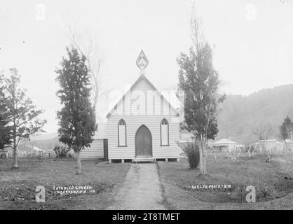 Chiesa cattolica, Ngaruawahia, nuova Zelanda -, veduta della piccola Chiesa cattolica in legno a Ngaruawahia, nuova Zelanda. La chiesa ha un sentiero che porta alla porta d'ingresso ed è incorniciata da due alberi piantati nei prati. Ci sono colline in lontananza. (Probabilmente Green & Colebrook, mercanti, con una filiale a Ngaruawahia, nuova Zelanda) intorno al 1910. Una copia in William A Price Collection Foto Stock