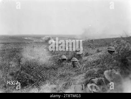 Le truppe neozelandesi in posizione di buco del guscio durante i bombardamenti da parte dell'artiglieria tedesca in Francia, prima guerra mondiale, le truppe neozelandesi che occupano posizioni di buco del guscio su un terreno leggermente più alto guardano i proiettili tedeschi che scoppiano più lontano durante la prima guerra mondiale in Francia. Per lo più sono visibili solo le teste e le spalle dei neozelandesi. Fotografia scattata nei pressi di Achiet-le-Petit il 22 agosto 1918 Foto Stock