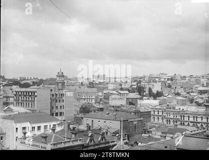 Vista di Wellesley Street e dell'area circostante, vista panoramica da uccelli che guarda a sud-est dalla vicinanza di Elliot Street. Wellesley Street è appena visibile al centro a sinistra con la torre dell'orologio della Auckland, New Zealand Public Library che si affaccia sopra il tetto dell'edificio YMCA. Altri edifici identificabili sono la Auckland, la New Zealand Savings Bank, i locali della Cousins & Cousins Ltd, la Young Women's Christian Association, la Mutual Life Insurance Society, la People's Palace Dining Room (15 Wellesley Street). All'orizzonte nel centro si trova l'Auckland, New Zealand Hospital. Foto Stock